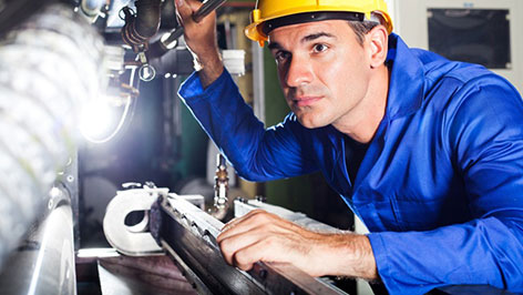 Real technician inspecting lift equipment during maintenance